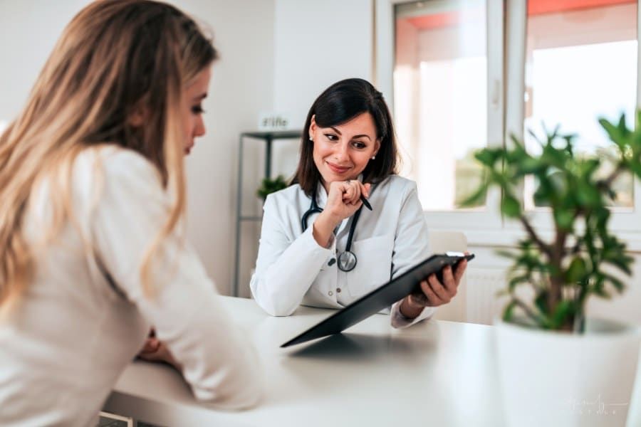 patient looking at papers doctor is showing her over a desk