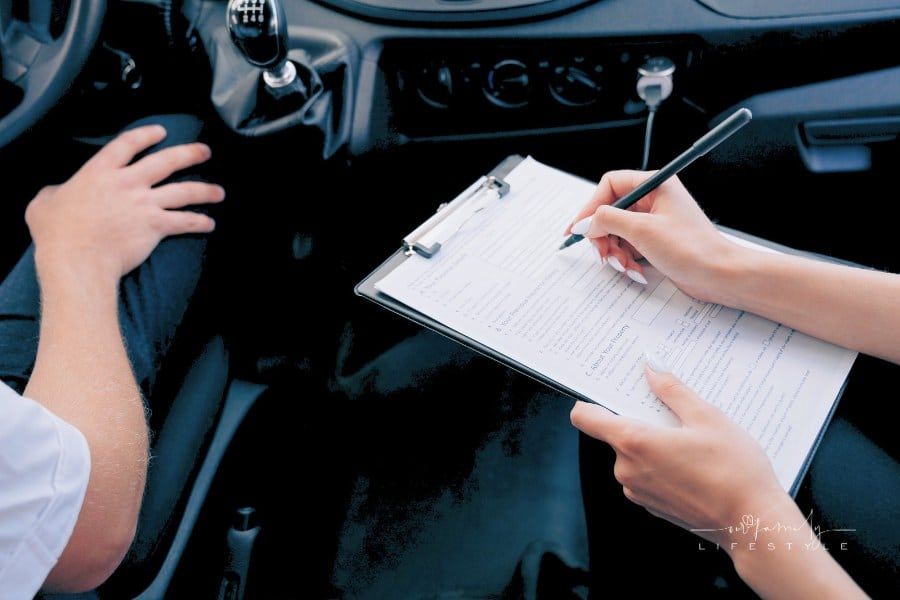 woman writing on a clipboard inside a car