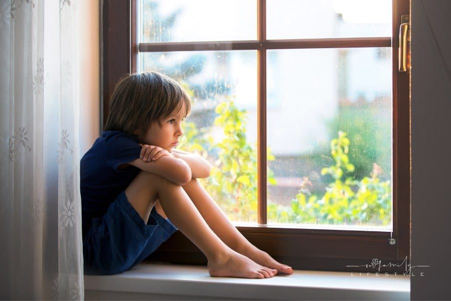 Sad child, boy, sitting on a window shield