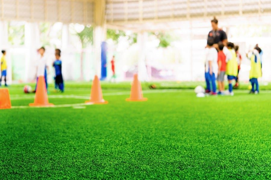 children playing field day games on painted field with cones
