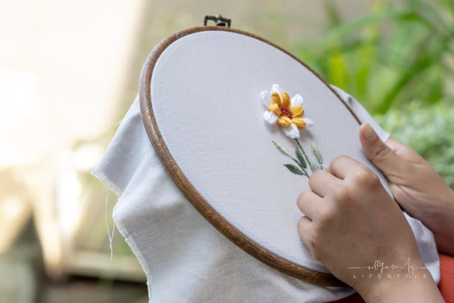 Person Doing Embroidery on White Cloth