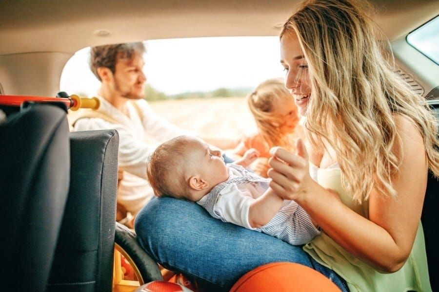 Young parents and happy kids having picnic in car