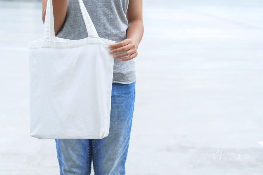 hipster woman holding white tote bag for mock up blank template