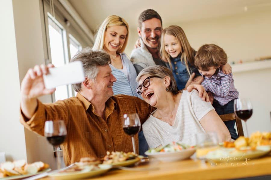 Multi-generation family gathering at table for a picture together