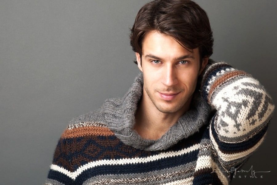 male model in sweater smiling at camera