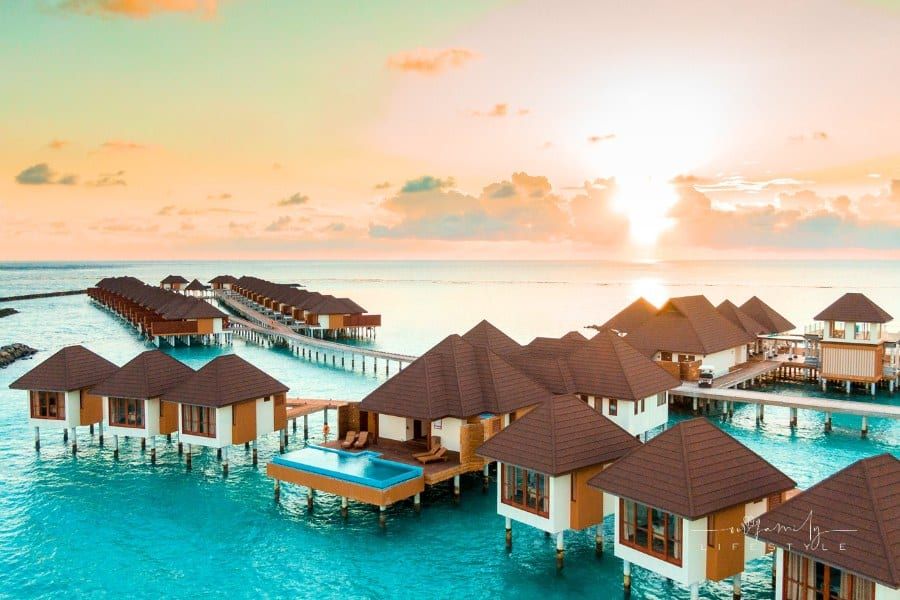 Brown and White Wooden Houses on Body of Water during Sunset in Maldives