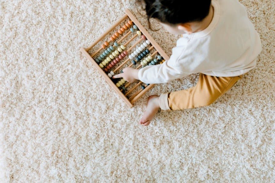 Top View of a Child Playing with an Educational Toy on carpet