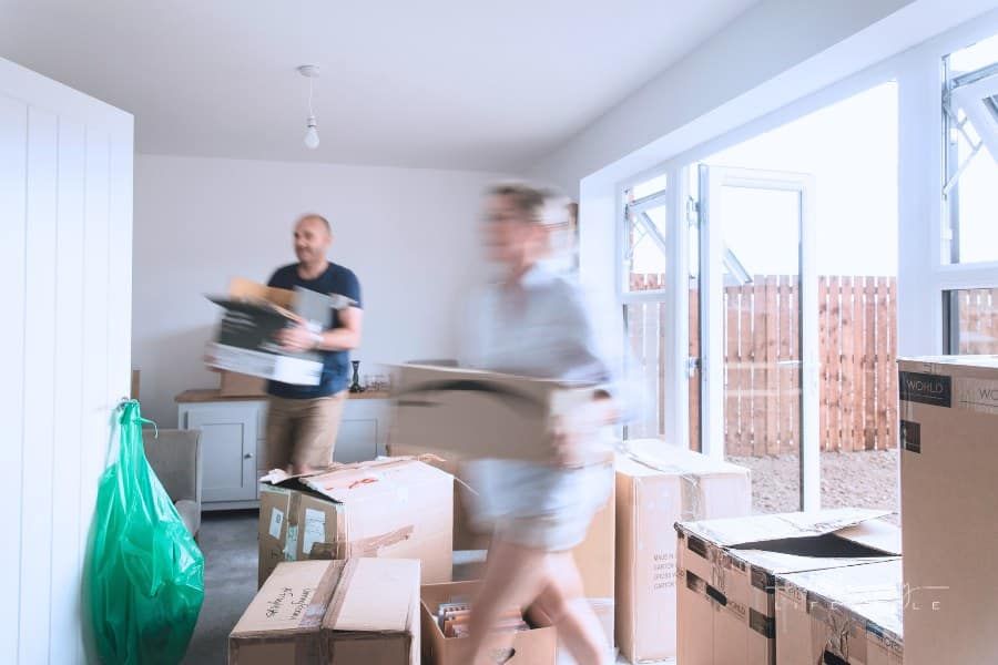 mature couple moving boxes into new downsized home