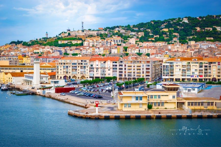 Harbor and city with buildings along the waterfront at Sète, South of France, Europe. View from cruise ship deck.
