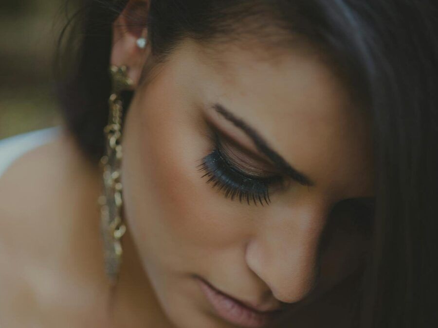 Intimate close-up of a woman with elegant jewelry and makeup, highlighting beauty.