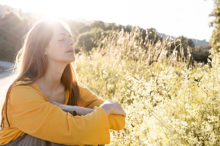 woman in nature enjoying the sunlight