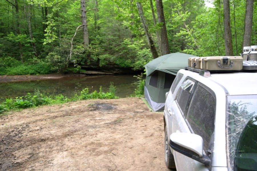 SUV and tent in creek side campsite