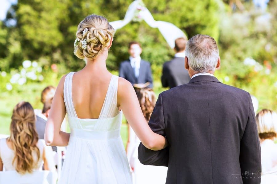 father walking his bride daughter down the aisle of outdoor wedding