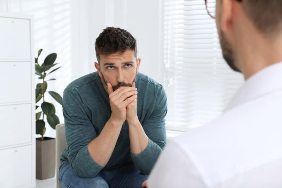Psychotherapist Working with Drug Addicted Man Indoors