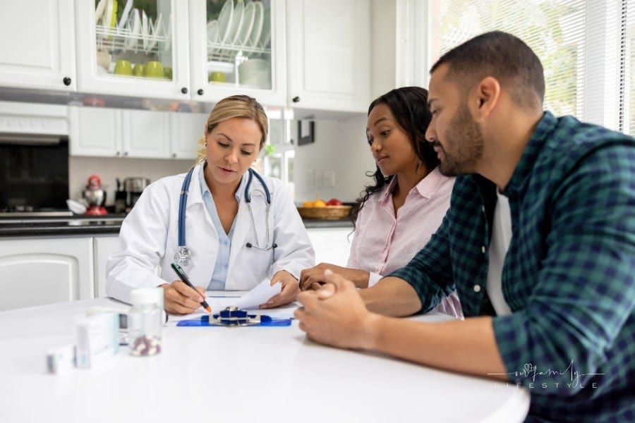 Doctor on a house call talking to a couple at their home