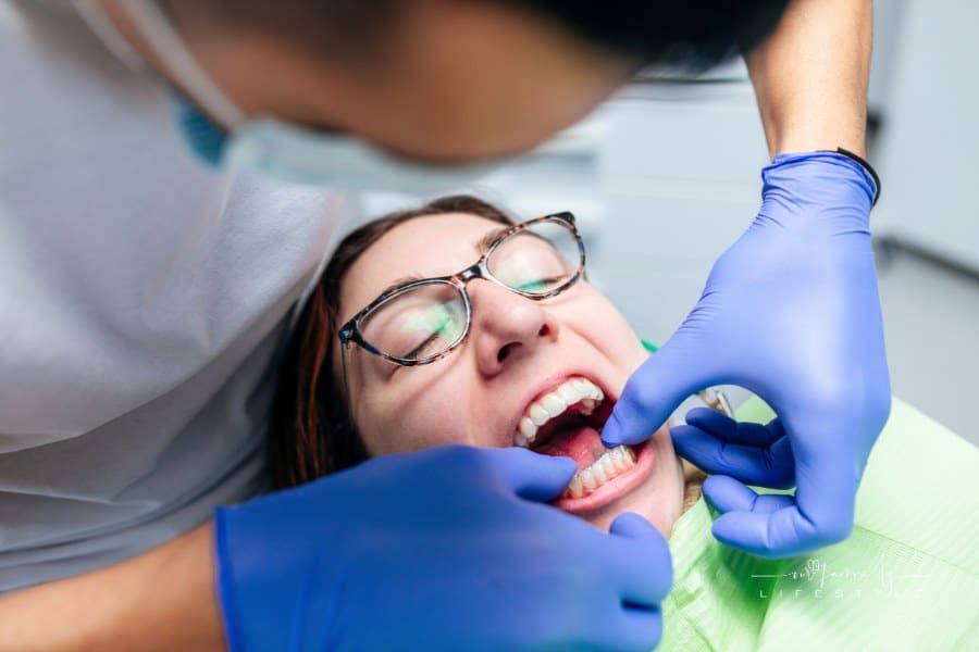 Orthodontist inserting clear aligners in woman's mouth