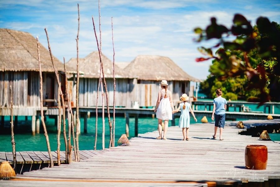 How To Plan An International Vacation With Your Family- A group of people walking on a dock by a body of water