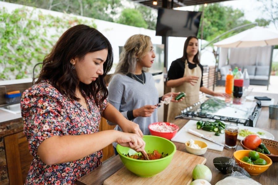 Group of friends cooking in outdoor kitchen