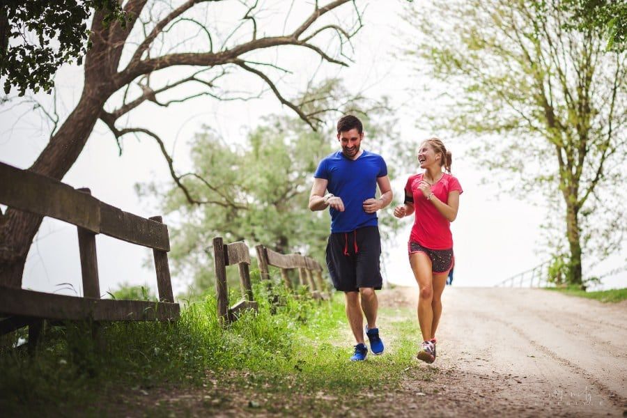 happy couple running together on dirt road