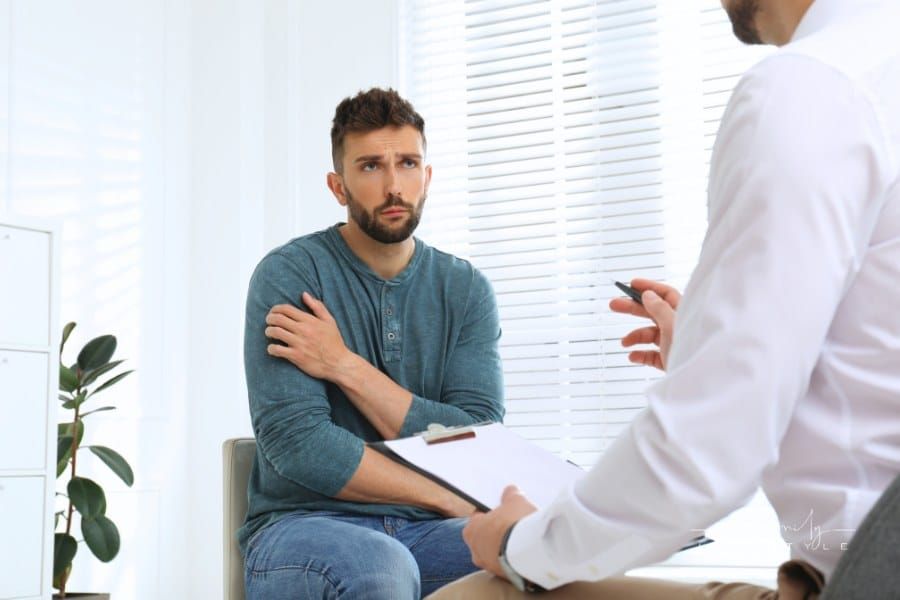 Psychotherapist Working with Drug Addicted Man Indoors