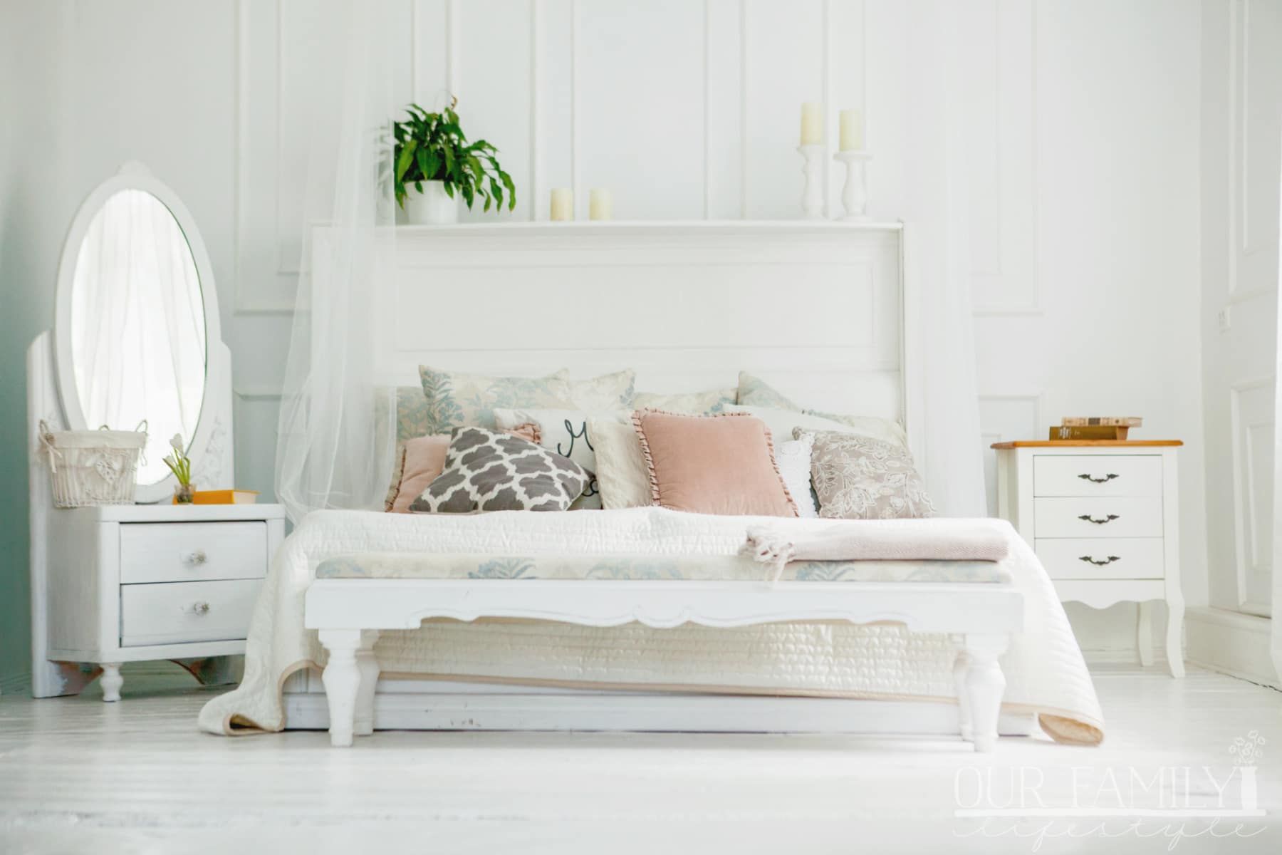 Scandinavian style white bedroom. Four pillows are on the bed. Modern interior.