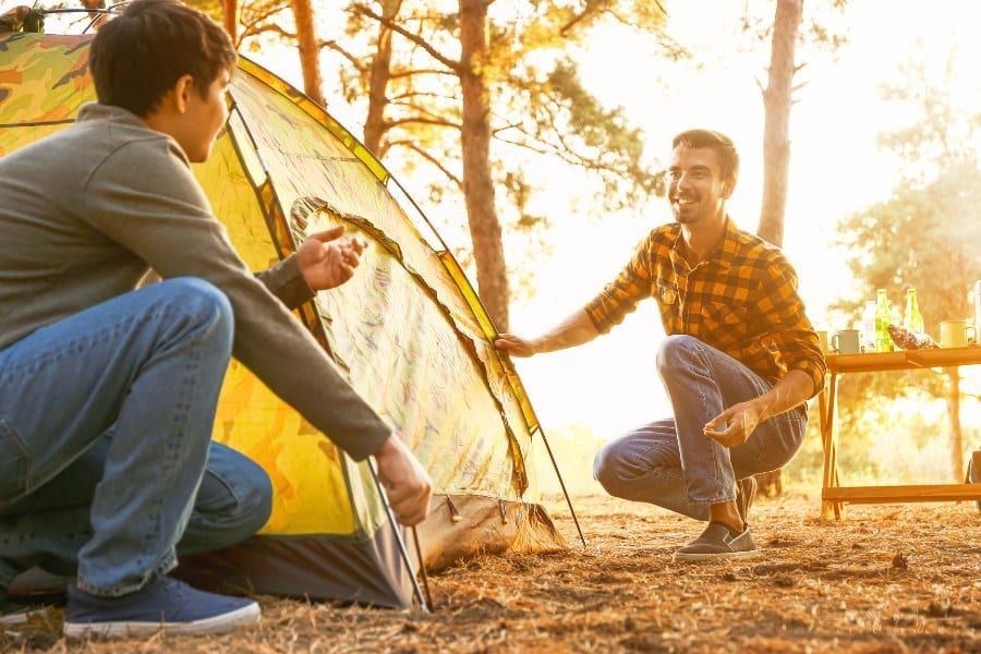 father and son pitching a tent