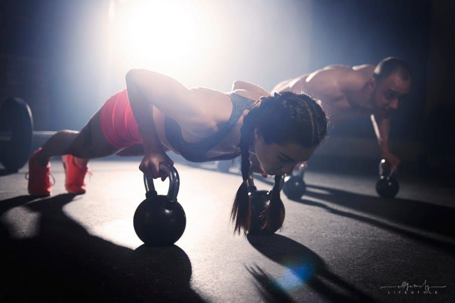 crossfit athletes exercising with dumbbells at the gym