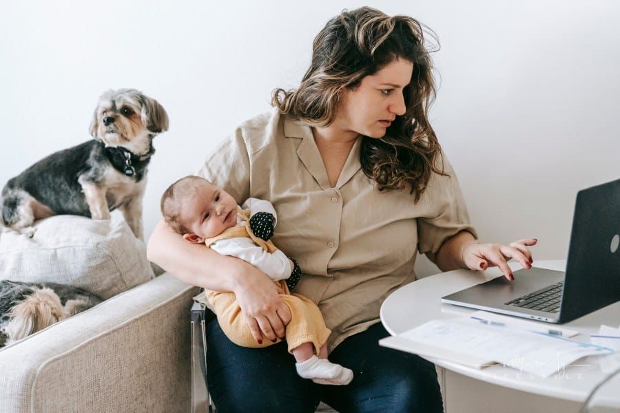 Mother Carrying Her Baby while Working From Home