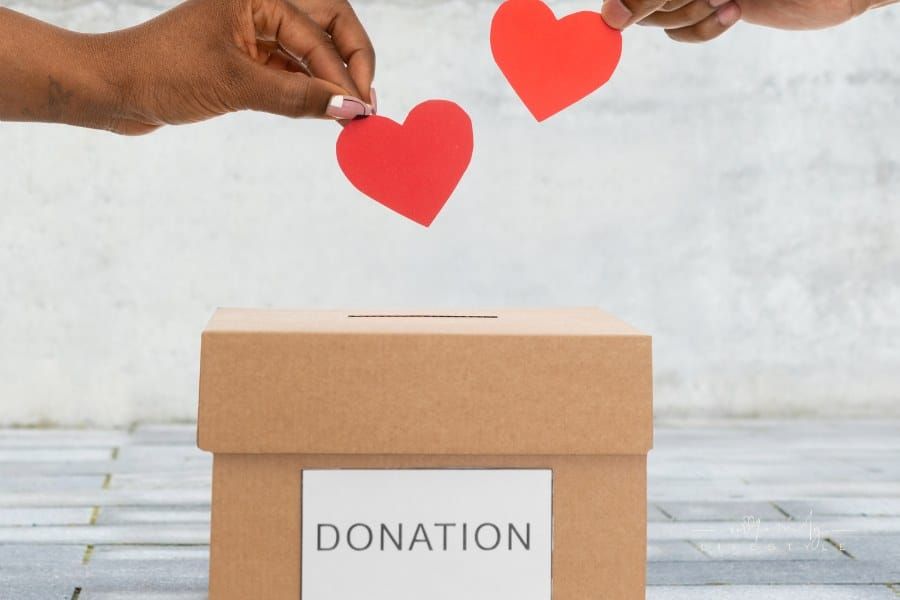 Hands Putting Hearts into Donation Box