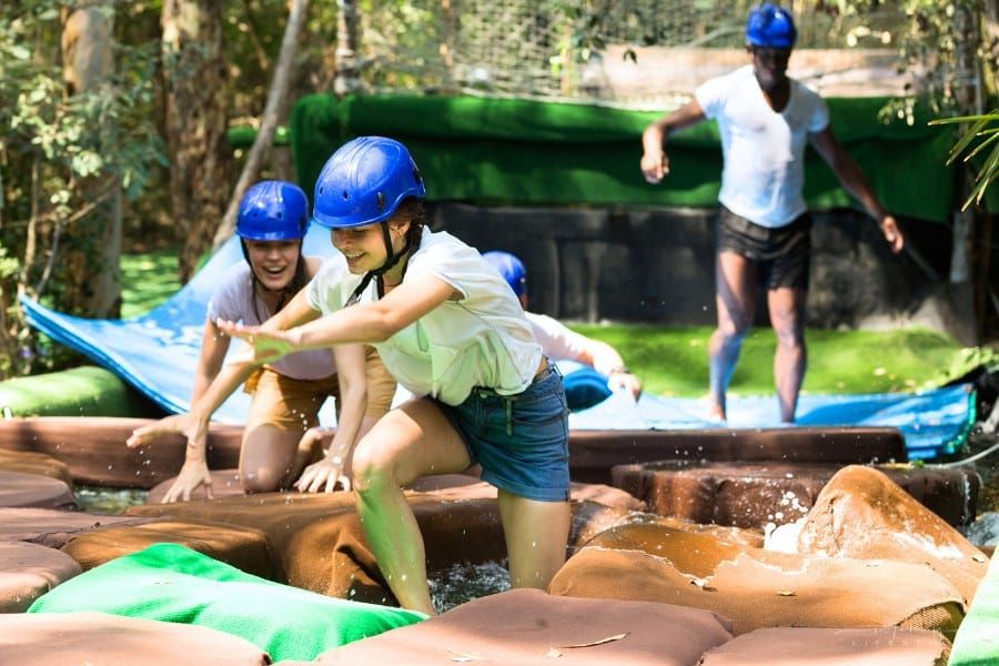 Team of friends overcomes an obstacle course in an amusement park