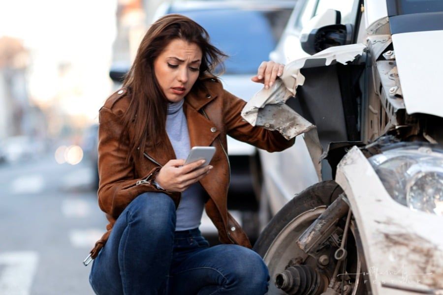 distraught woman on phone after car accident