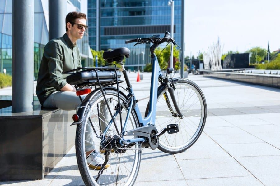business man sititng beside his commuter electric bike