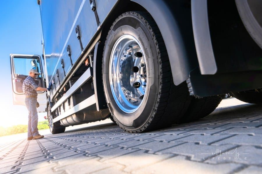 Trucker Inspecting Semi-Trailer Tire