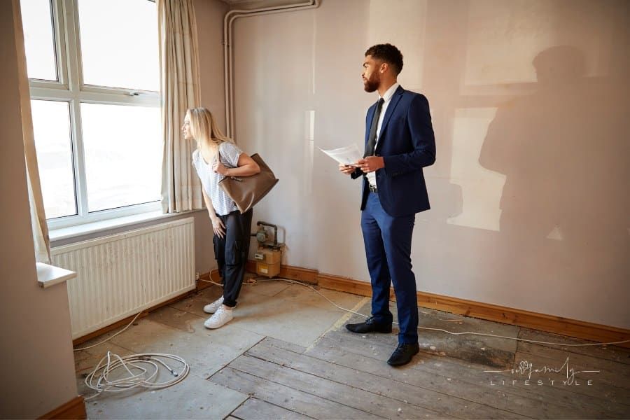 Woman looking at house in need of repair with realtor
