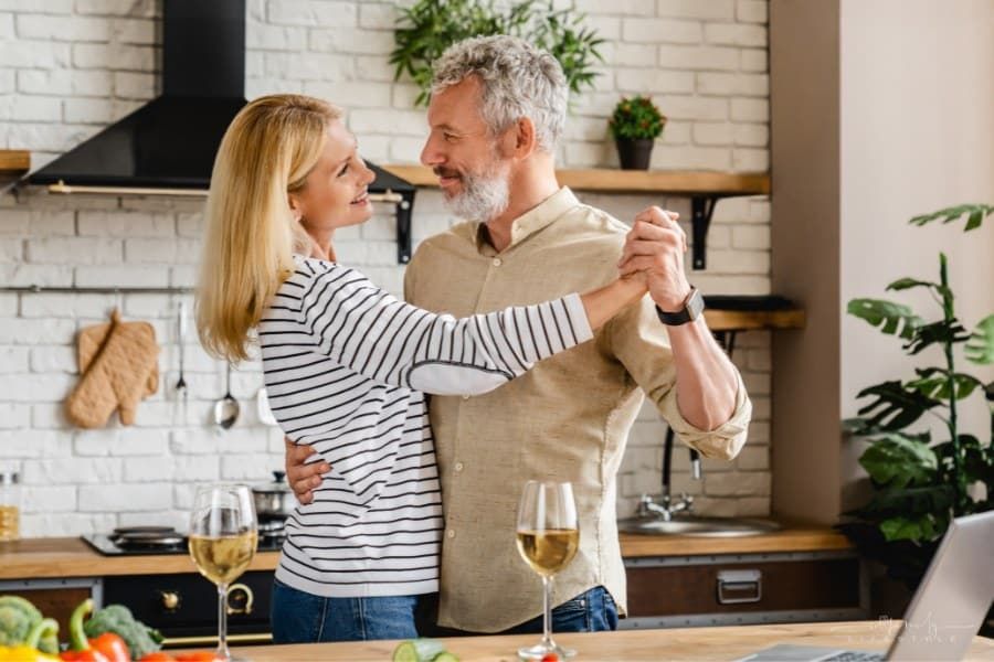 middle age couple dancing in their kitchen