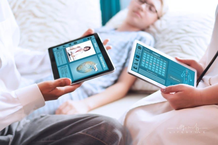The concept of medical tourism on tablet in doctor's hands with young patient in background