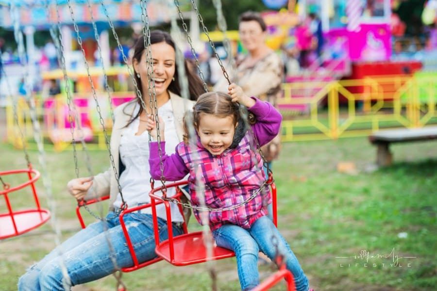 Mother and Daughter having fun at fair on chain swing ride