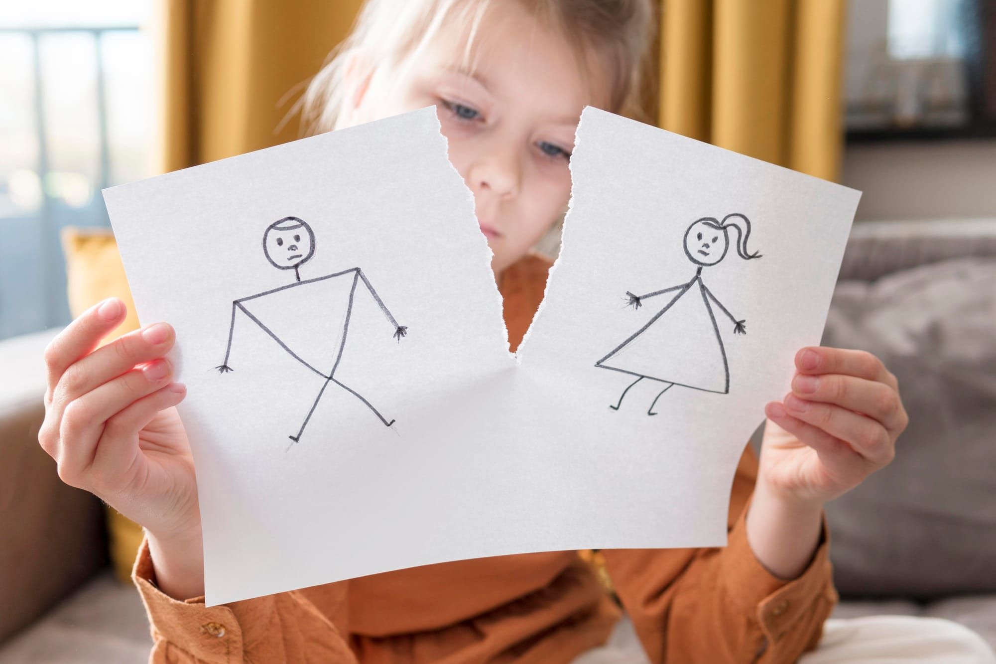 Medium shot girl holding broken drawing of stick figure couple