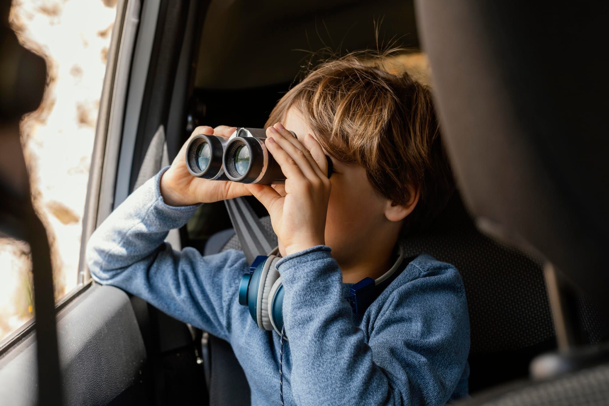 portrait-young-boy-car-with-binoculars