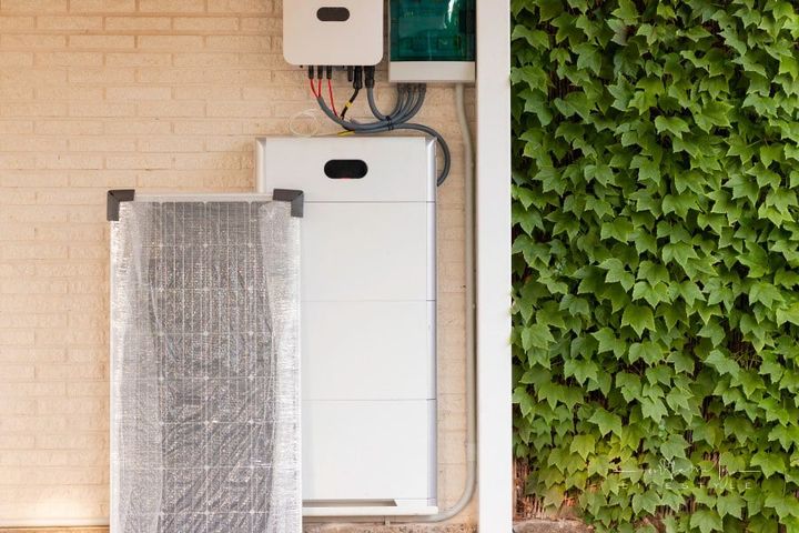 Electrical system for solar energy installation with solar panel, battery and inverter with plants on one side