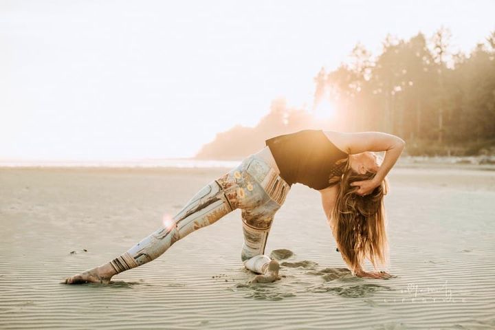 woman doing yoga poses at sunset on sandy beach