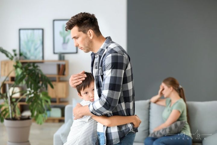 father consoling young son during parent's breakup