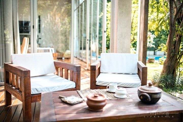 two outdoor teak outdoor chairs and table on deck