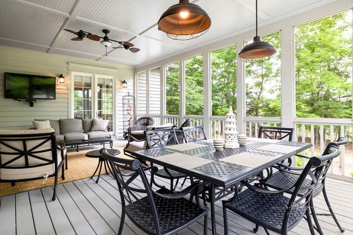 elegant covered backyard patio with black metal furniture and tropical ceiling fans