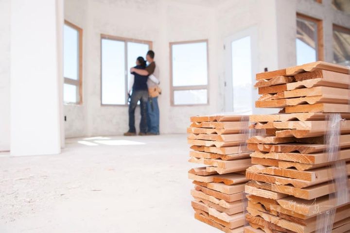 couple looking at window inside new home under construction