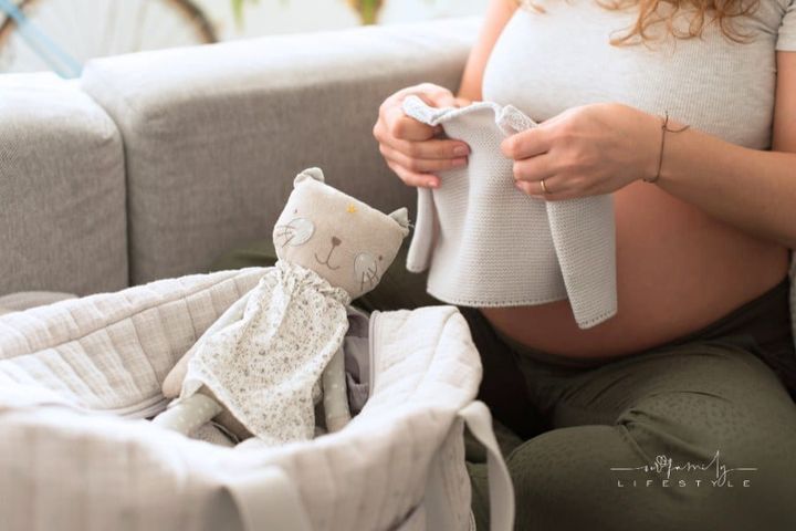 Pregnant Woman Packing Maternity Bag with Stuffed Toy