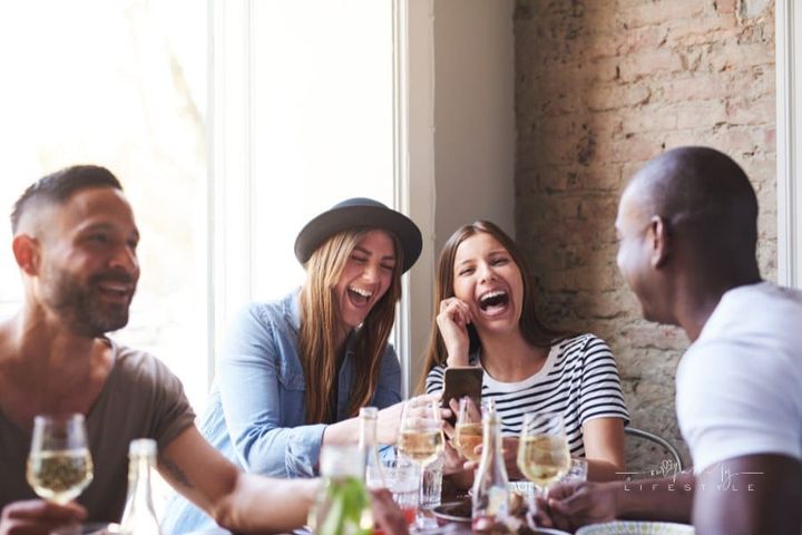 Laughing Friends Having Wine and a Meal Together