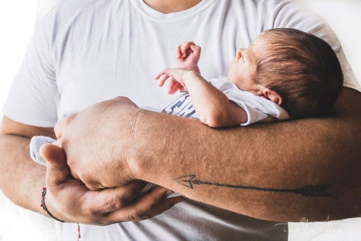 father holding newborn baby in his arms