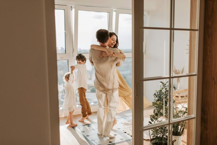 Happy family enjoying a moment of togetherness and joy while dancing in their living room.