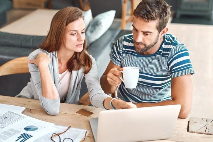 couple working on income taxes at laptop